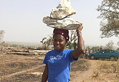 People from surrounding villages bring in stones to fill the foundation