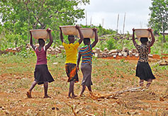 Women carry water to make the cement blocks