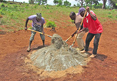 The sand and concrete are mixed by hand