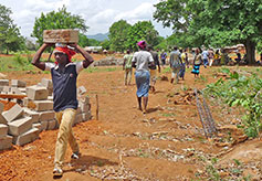 Workers carry blocks to the construction site