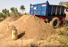 A load of sand is dumped near the broken pump well