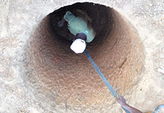 A worker lines the well with cement